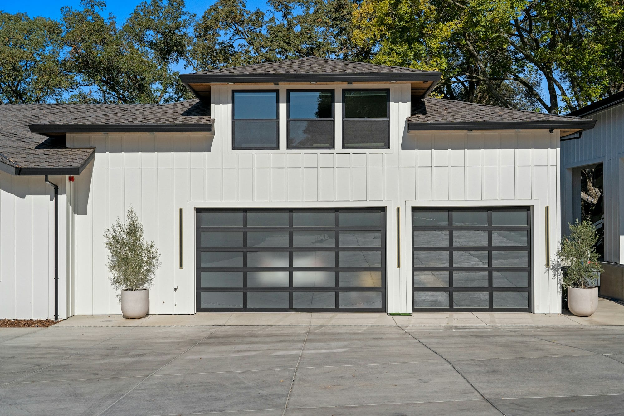 Modern white house with two glass-panel garage doors